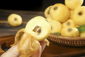 Fresh Loquat White Flesh and Seed Close-up with Whole Fruits from Suzhou China on Wooden Table