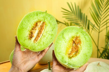 Fresh Honeydew Melon Halves with Jade Green Flesh and Seeds in Hands