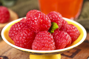 Fresh Red Raspberries in Yellow Bowl on Wooden Table - Healthy Organic Summer Berries