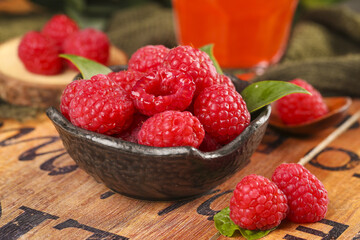 Fresh Red Raspberries in Rustic Bowl with Mint Leaves on Wooden Background