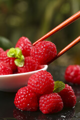 Fresh Red Raspberries with Wooden Chopsticks and Mint Garnish - Healthy Berry Fruit Close-up