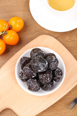 Xinjiang Tianshan Dried Plums Sweet Sour Fruit Snack with Fresh Tomatoes and Tea on Wooden Table