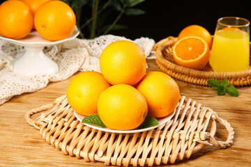Fresh Oranges from Hubei Zigui Mountain Region in Wicker Baskets with Orange Juice on Wooden Table