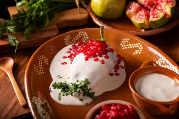 Chiles en Nogada, a typical Mexican dish. Poblano chile stuffed with meat and fruit, topped with a...