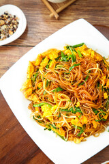 Homemade stir-fried vermicelli noodles with scrambled eggs on white plate