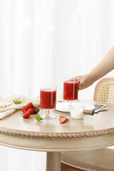 Fresh Strawberry Juice Summer Drinks on Wooden Table with Rattan Chair