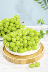 Fresh Green Grapes on Wooden Tray with Natural Sunshine Lighting and Palm Leaves Background