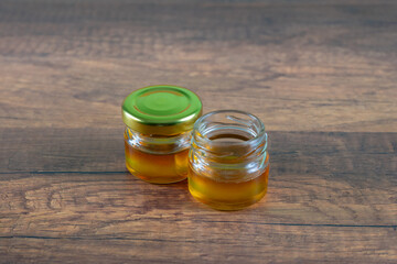 A small golden honey jar was placed on a wooden table.