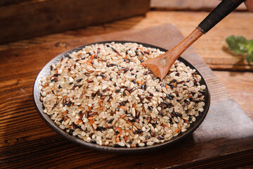 Organic Mixed Tricolor Rice Grains in Rustic Bowl with Wooden Spoon on Wood Table