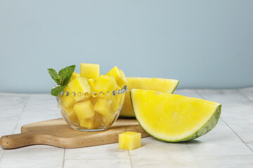 Fresh Yellow Watermelon Cubes from Hainan with Mint Garnish on Wooden Board
