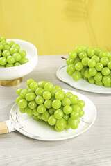 Fresh Green Grapes on White Plates with Yellow Background - Healthy Fruit Display