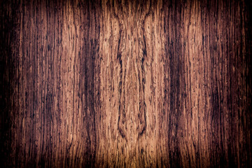 background is made of old wood. an old board. the texture of a rustic table. Cocobolo, Dalbergia, red wood, a place for a text or object, frame, vignetting, view from above. the effect of aging