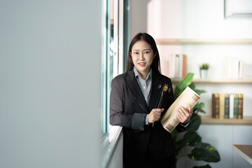 Legal Professional Holding Gavel and Case Files in Modern Office