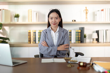 Young Lawyer. Confident female attorney in modern office with arms crossed.