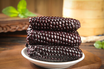 Purple Glutinous Corn from Xishuangbanna Yunnan Province China Traditional Sticky Corn Variety on Wooden Table