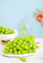 Fresh Green Grapes with Spoon on White Plate - Healthy Fruit Eating Concept