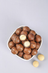 Macadamia Nuts in Bowl with Cracked Shells Showing Creamy White Kernels - Premium Healthy Snack Food Ingredient
