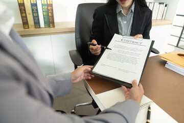 Contract Review. Businesswoman presenting legal document for client signature.
