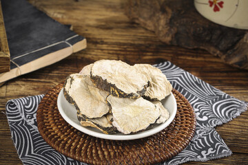 Traditional Chinese Dried Maca Root Slices from Yunnan Province on Wooden Table with Herbal Medicine Setup