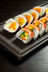 Fresh Sushi Rolls with Salmon and Avocado on Wooden Platter - Japanese Cuisine Food Photography