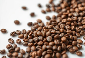 Fototapeta premium Close-up of roasted coffee beans scattered on a white surface, ample copy space, overhead, product