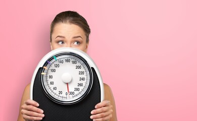 Diet and weight loss. Young woman hold floor scale