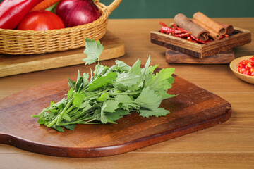 Fresh Organic Green Leafy Vegetables and Herbs on Wooden Cutting Board with Kitchen Ingredients