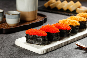 Exquisite Japanese Sushi with Orange Roe Wrapped in Seaweed on Marble Plate