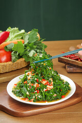 Asian Style Fresh Green Vegetable Salad with Wild Garlic and Herbs on Wooden Table