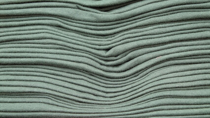 Background pattern and texture of a new stack of green tosca t-shirts. The concept of the...