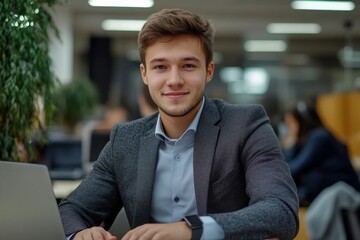 Smiling young man businessman in a business suit sits and works in the office on a laptop online, texts, chats with partners, clients, Generative AI
