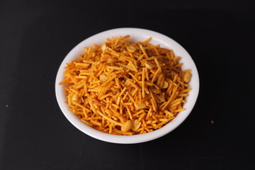 Fried and Spicy Farali chevdo, chivda, chewada is a very popular Gujarati snack, white bowl, pouch packing common street snack from India. - Image