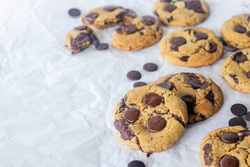 freshly baked homemade chocolate chip cookies on baking paper background