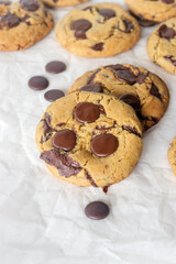 freshly baked homemade chocolate chip cookies on baking paper background