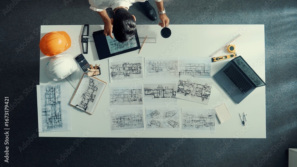 Poster top down aerial view of architect engineer placing building blueprint on table while checking and ch