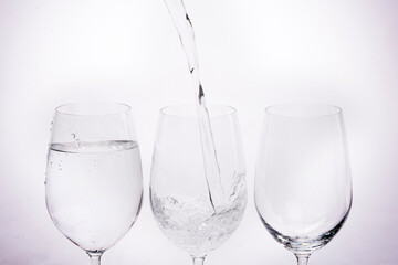 Three glasses of wine with water poured into them in the concept of quitting alcohol.