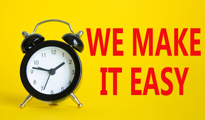 We make it easy symbol. Beautiful yellow background with alarm clock with words We make it easy. Business concept. Copy space.