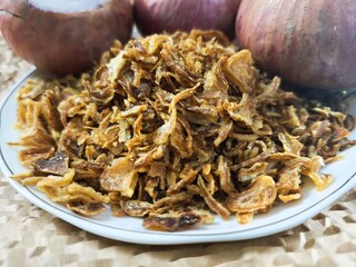 Close-up of crispy fried shallots, bright yellow and delicious.