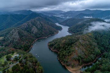 Aerial view of a meandering river valley, misty mountains