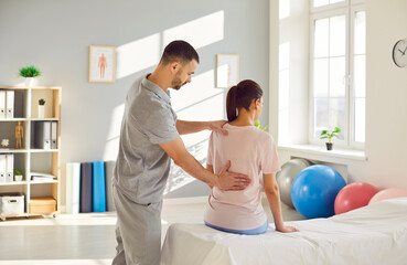 Post traumatic rehabilitation, female back spine massage, physical therapy by professional male...