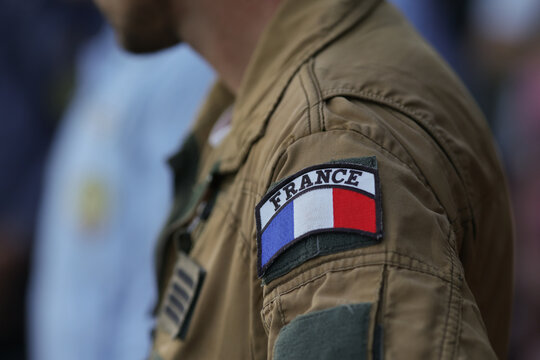 Shallow depth of field (selective focus) details with the French flag on the flight suit of a french pilot.