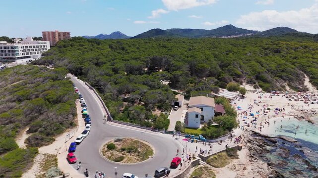 Aerial Drone Panning Shot Of Lively Cala Agulla Beach With Sunbathers And Turquoise Mediterranean Sea, Mallorca, Spain.