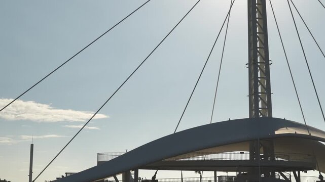Modern architectural structure with cables and central steel column against sky
