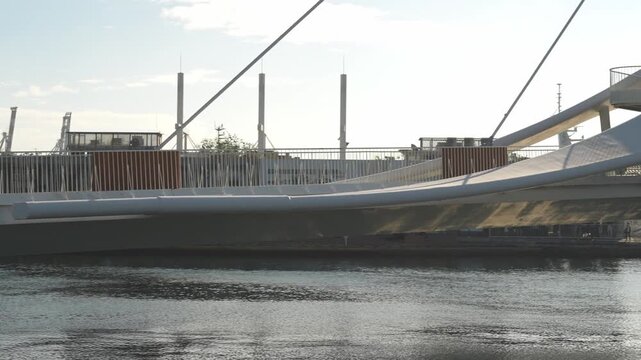 Modern Suspended Pedestrian Bridge Over Urban River at Sunset, Minimalist Scene