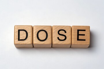 Wooden Blocks Spelling Out the Word DOSE on a White Background dose