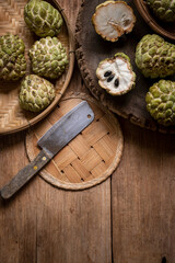Custard apples on a wooden basket placed on an old wooden floor, vintage still life style.
