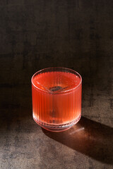 Retro cocktail with clear ice cube, moody lighting, overhead composition