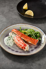 Kamchatka crab phalanges with herb sauce and greens, bright lighting, overhead plate composition