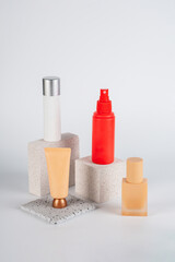 Plastic white tube for cream or lotion. Skin care or sunscreen cosmetic, Cosmetic red bottle. Womens cosmetic accessory for makeup with stylish props on white background.