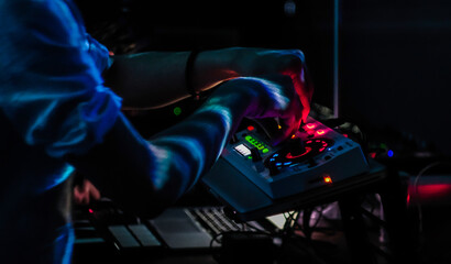 DJ performs in nightclub, party lighting creating vibe, atmosphere of nightlife